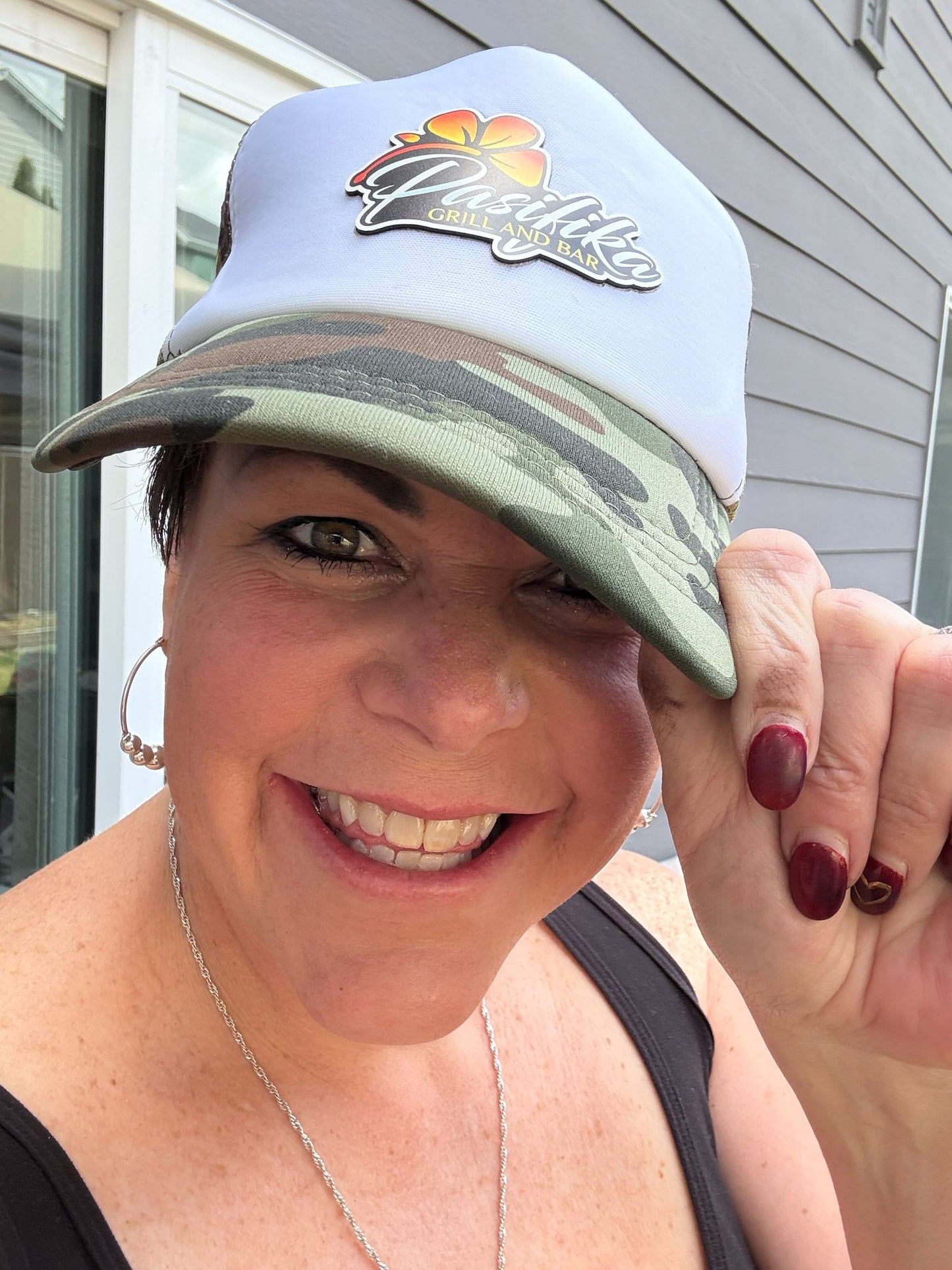 Woman wearing pink distressed Pasifika Grill and Bar patch logo cap