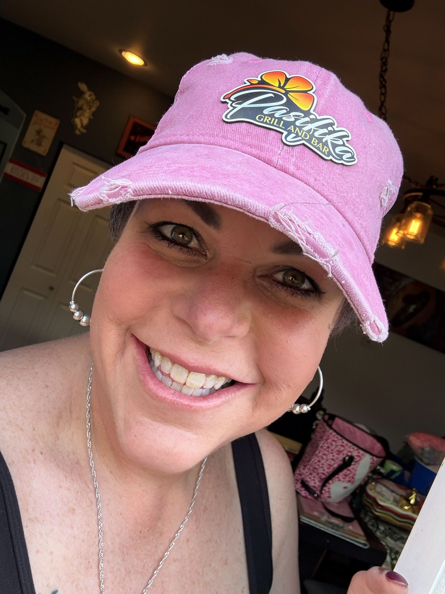 Woman wearing white and camo Pasifika Grill and Bar patch logo trucker cap