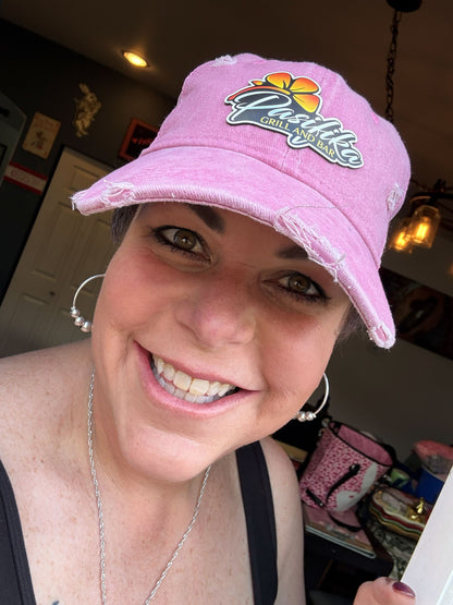Woman wearing white and camo Pasifika Grill and Bar patch logo trucker cap